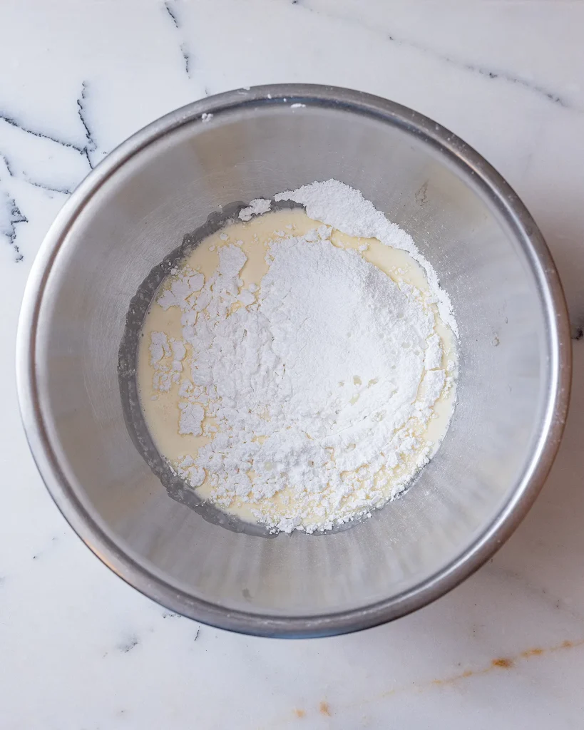 Add powdered sugar to rosemary whipped cream
