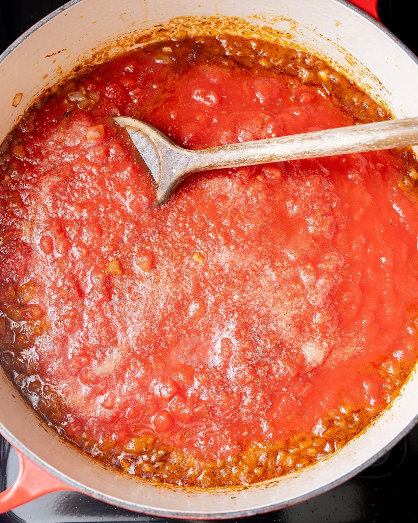 Add crushed tomatoes with onion