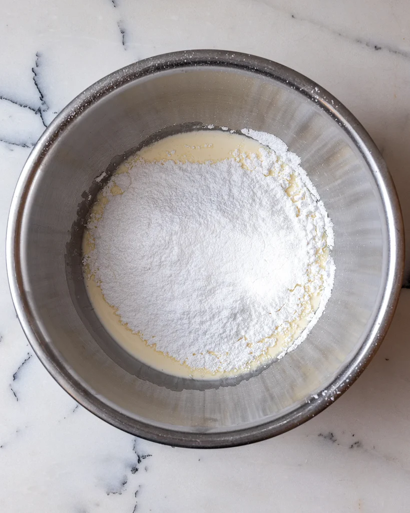 Add powdered sugar to frosting