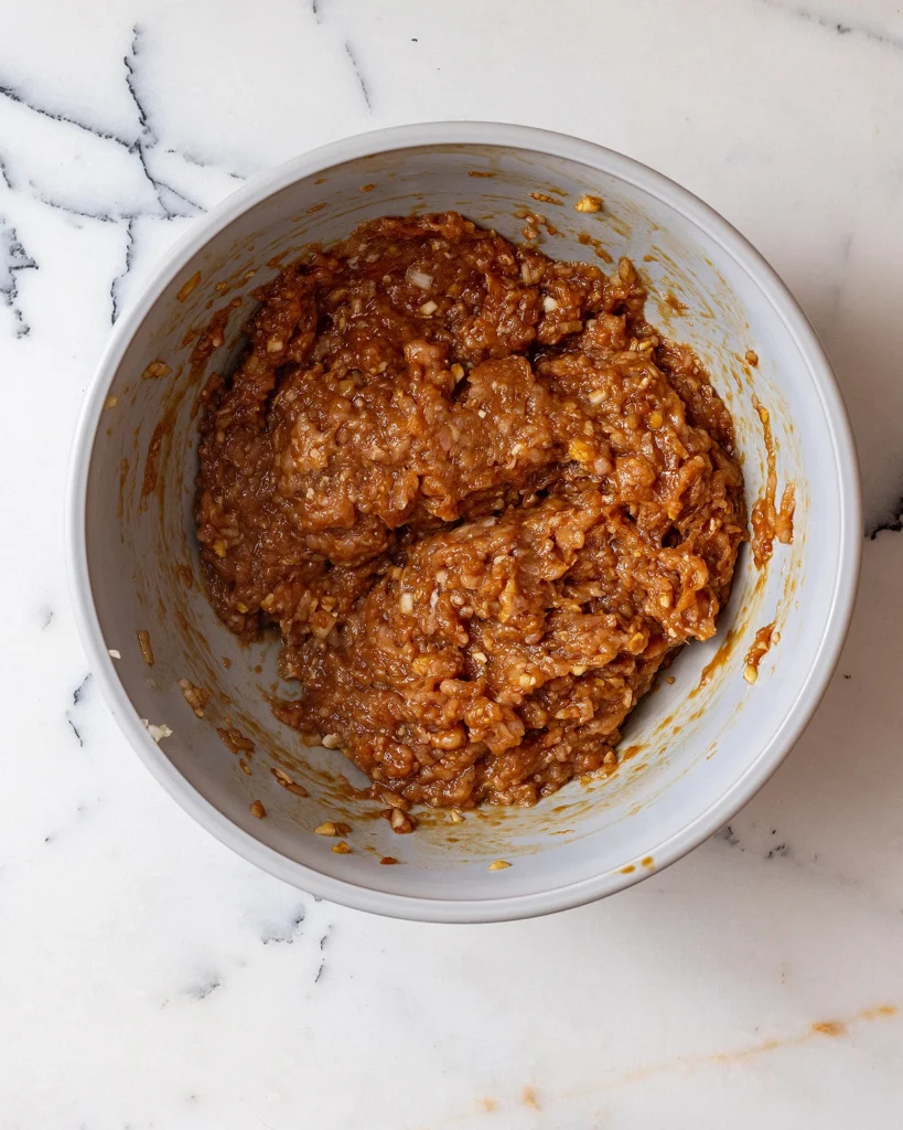 Mix chicken with aromatics and tamari