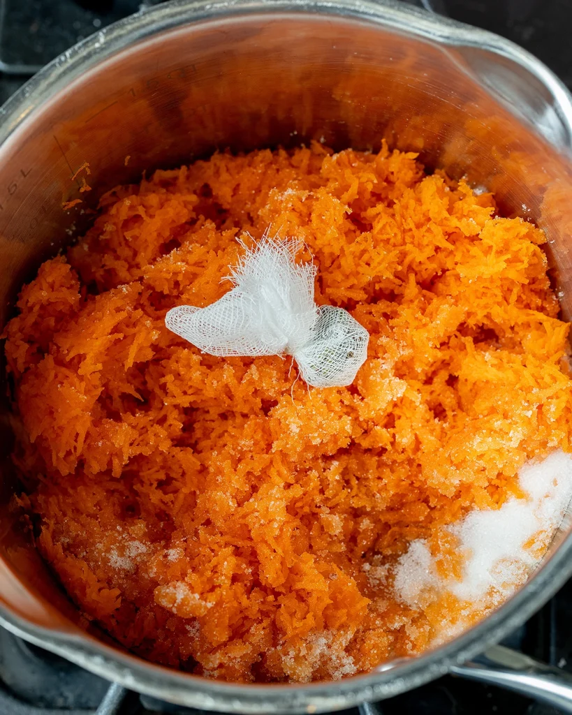 Add sugar and cardamom to grated carrots